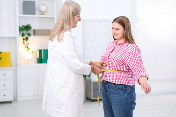 How weight loss injections work, showing a doctor measuring a patient's waist during a weight management consultation.